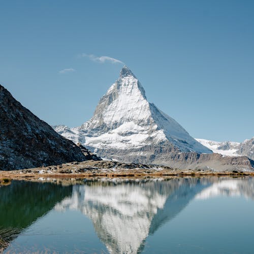 Snow-capped mountains reflected in a still lake